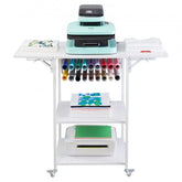White foldable 3-tier heat press stand with wheels, vinyl roll holders, and storage for supplies.