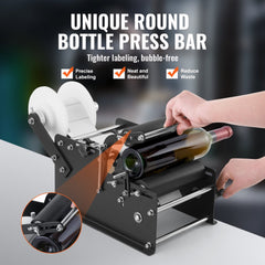 Black manual round bottle labeling machine applying white label to wine bottle, with adjustable frame and rollers.