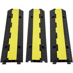 Three black and yellow 2-channel cable protector ramps arranged side by side.