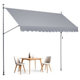 Gray retractable patio awning extended over wooden table and chairs.