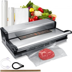 Silver Bostome vacuum sealer with dual pumps, starter bags, roll, cutter, and fresh vegetables.
