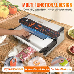 Silver Bostome vacuum sealer with control panel sealing a bag of meat on a wooden table with vegetables.