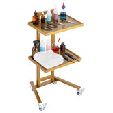 A golden 2-tier stainless steel lab cart with various salon or lab supplies.