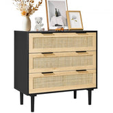 Black boho dresser with three rattan drawers and sturdy legs for versatile storage.