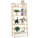 Natural trapezoid 4-tier bamboo ladder bookshelf with books, plants, and decor on shelves.
