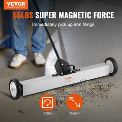 A 24-inch rolling magnetic sweeper with wheels picking up nails and screws from the floor.