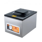 Stainless steel chamber vacuum sealer with orange control panel, pressure gauge, and black lid.