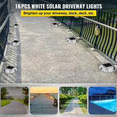16-pack of white solar-powered driveway lights installed along a paved path with black railings.