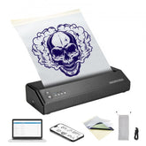 Portable wireless Bluetooth tattoo stencil printer with skull design on transfer paper, laptop, phone, and accessories.