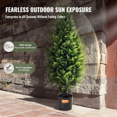Two 36-inch artificial cedar topiary trees in black pots against a brick wall, with UV resistance and certification badges.