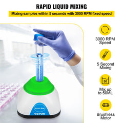 A hand in blue glove presses a blue-capped tube onto a green-based mini vortex mixer with 3000 RPM speed.