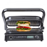 Black electric grill open with a sandwich on ridged plates and digital controls.