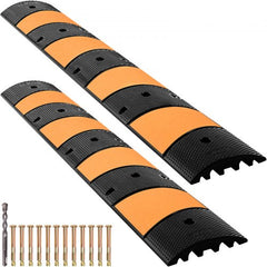 Black rubber speed bump with yellow stripes, featuring two channels for cable protection.