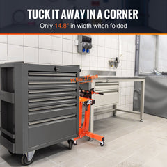 Gray cast iron rotating engine stand with 360-degree adjustable head, mounted on orange wheeled base next to tool cabinet.