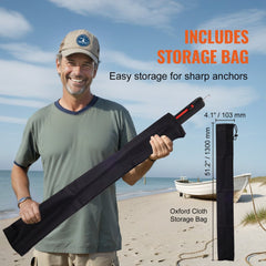 Man holding a 36-inch galvanized steel sand spike anchor with storage bag on a beach.