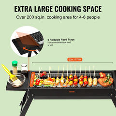 Black steel portable charcoal grill with 23-inch cooking area, foldable trays, and skewers on grate.