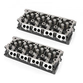 Pair of cast-iron cylinder heads for 6.4L Powerstroke engine, fully assembled with valves and springs.