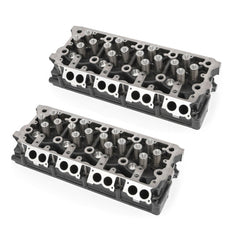 Pair of cast-iron cylinder heads for 6.4L Powerstroke engine, fully assembled with valves and springs.