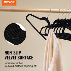 Black velvet slim hangers with non-slip surface and swivel hooks holding a white towel.