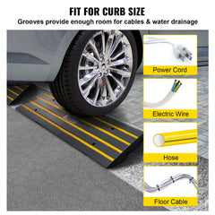 A car tire rests on a black rubber curb ramp with yellow stripes and cable grooves.