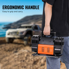Man holding orange Bostome dual-cylinder tire inflator with ergonomic handle by off-road vehicle.