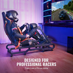 A man in racing gear sits in a heavy-duty racing wheel stand with Logitech wheel, pedals, and a large screen displaying a race.