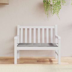 A gray Oxford fabric garden bench cushion is centered on a white slatted bench.