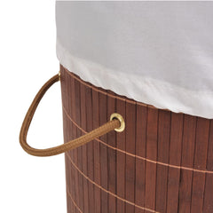 Brown bamboo round laundry hamper with white liner and leather handles.