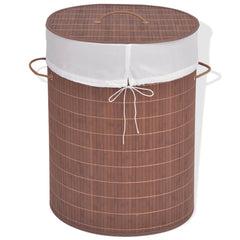 Oval brown bamboo laundry hamper with white woven liner and leather handles.
