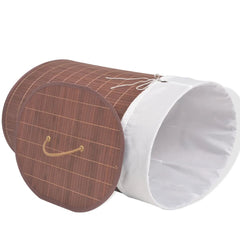 Oval brown bamboo laundry hamper with removable white liner and side handles.
