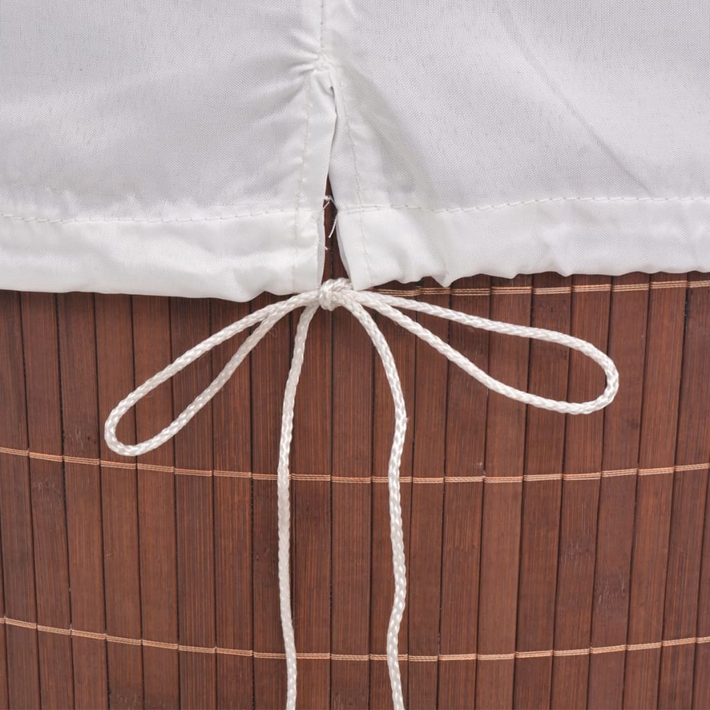 Oval brown bamboo laundry hamper with white removable liner and tie closure.