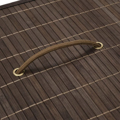Rectangular dark brown bamboo laundry hamper with woven handle on a bamboo mat background.