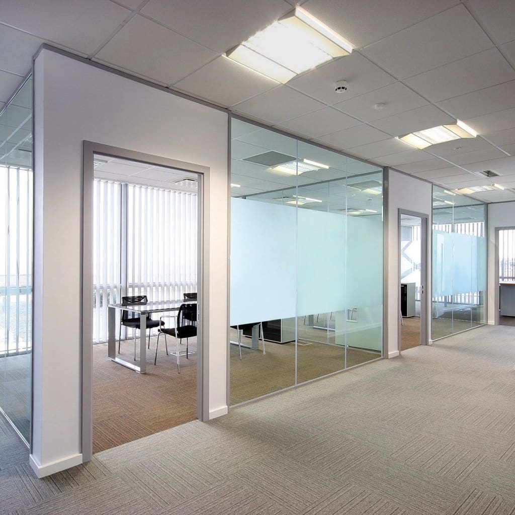 A modern office interior features glass walls with a frosted privacy film applied to the lower half.
