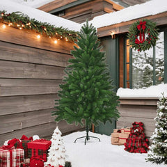 A 7-foot faux Christmas tree with lifelike green PE needles on a metal stand, surrounded by holiday decorations and snow.