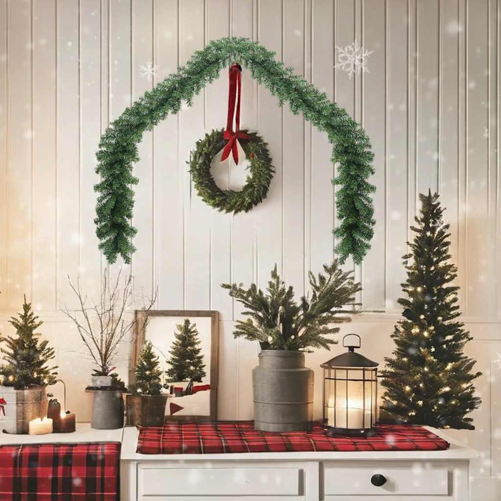 16 ft green PVC Christmas garland with 450 branches draped over a white wall.