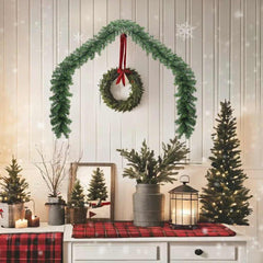 16 ft green PVC Christmas garland with 450 branches draped over a white wall.