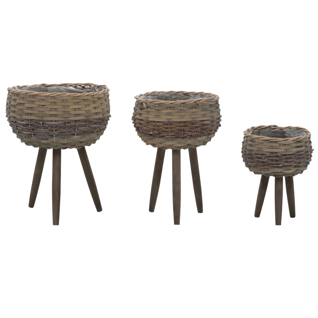 Three brown wicker planters in graduated sizes on wooden legs, with PE lining.
