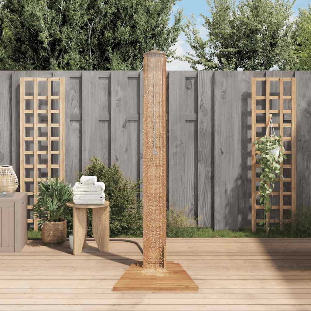 Solid teak garden shower with wooden base and riser on a sunny patio.