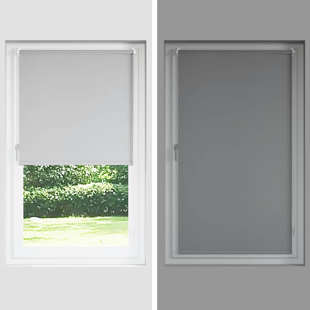 Gray blackout roller blind partially lowered on a white window frame in daylight and darkness.
