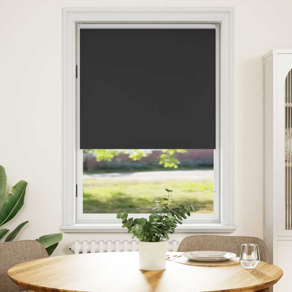 Black blackout roller blind, 31.5x68.9 inches, installed on a window in a living room.