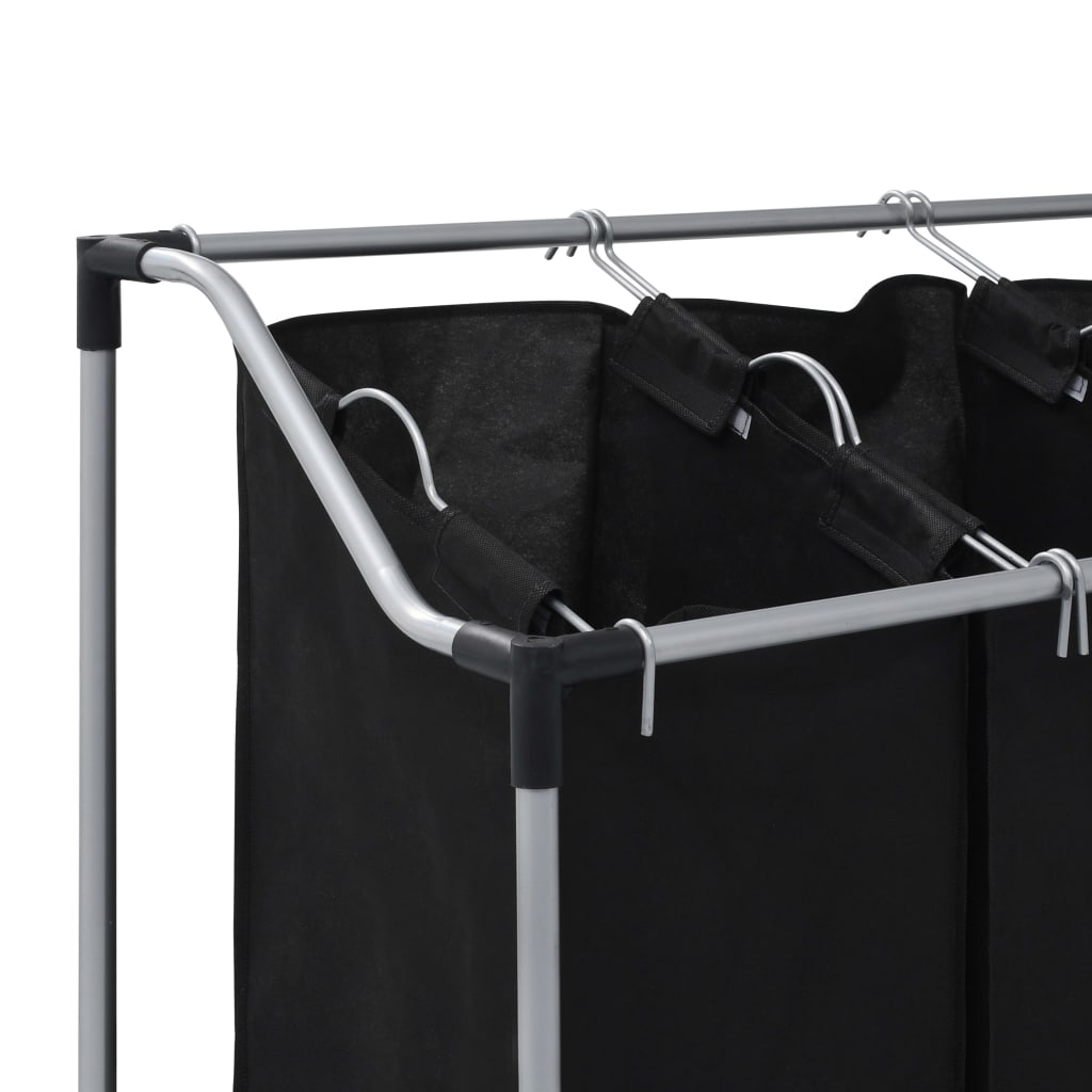 A black steel laundry sorter with three removable black fabric bags hanging from a top bar.
