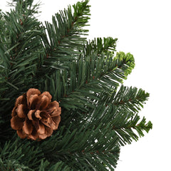 A 6 ft green artificial Christmas tree with attached pine cones and dense PVC branches.