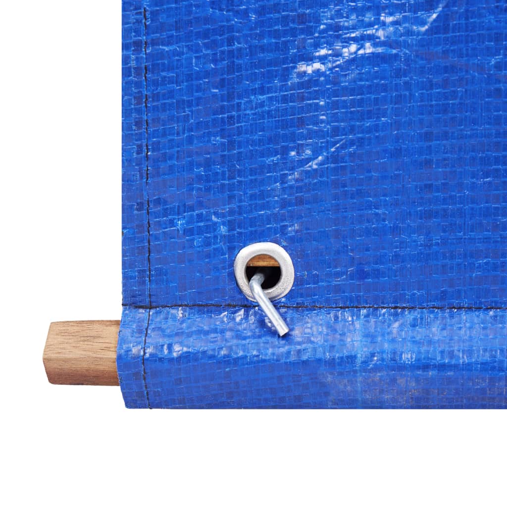 Close-up of blue PVC tarp with grommet and wooden frame on firewood storage shed.