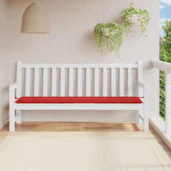 Red Oxford fabric garden bench cushion on white wooden bench in outdoor setting.