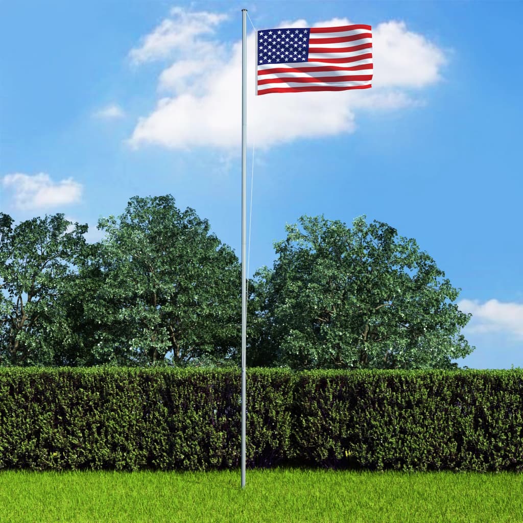 3x5 ft US flag made of durable polyester with brass grommets on a pole in a green yard.