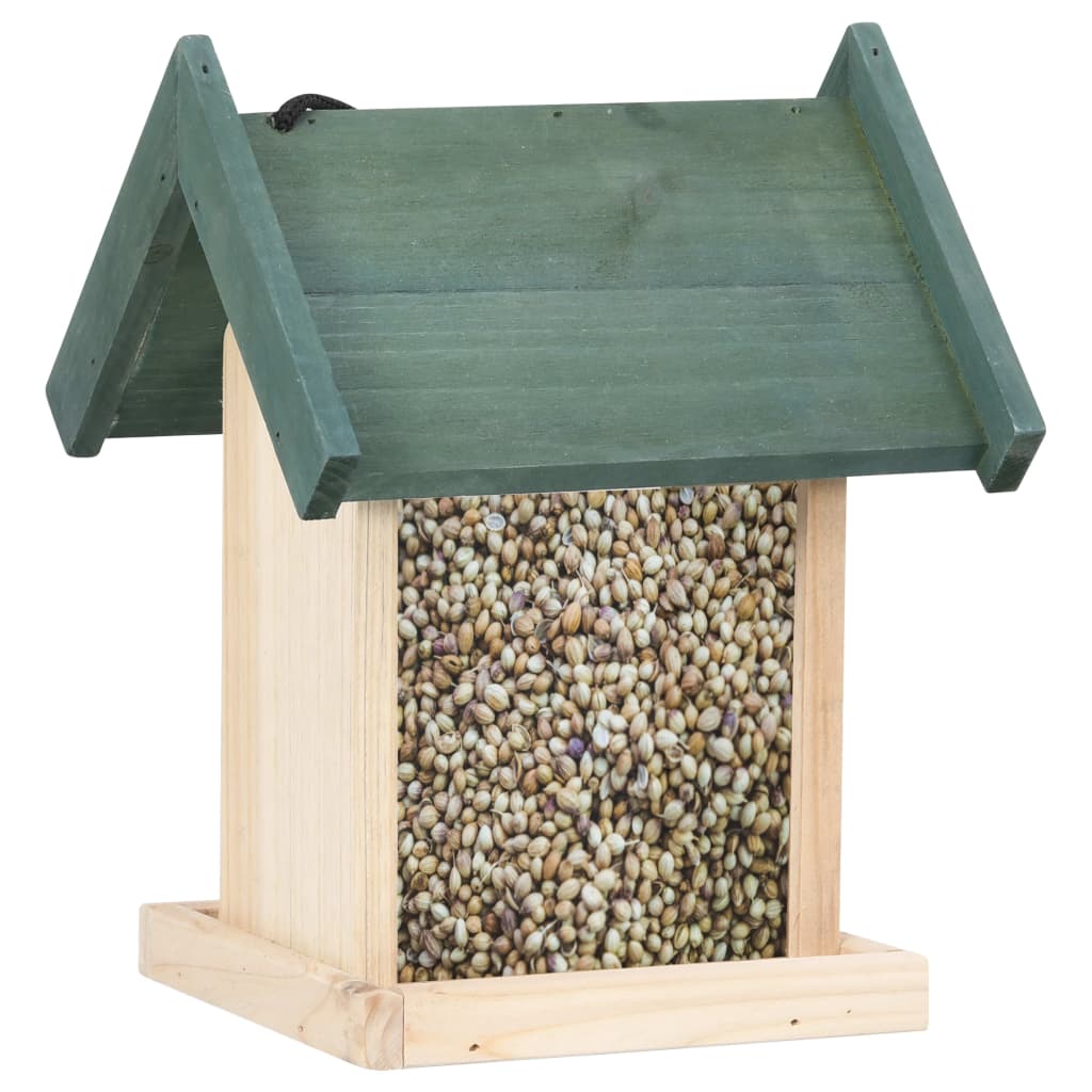 A wooden bird feeder with green roof, filled with seeds, on a stand.