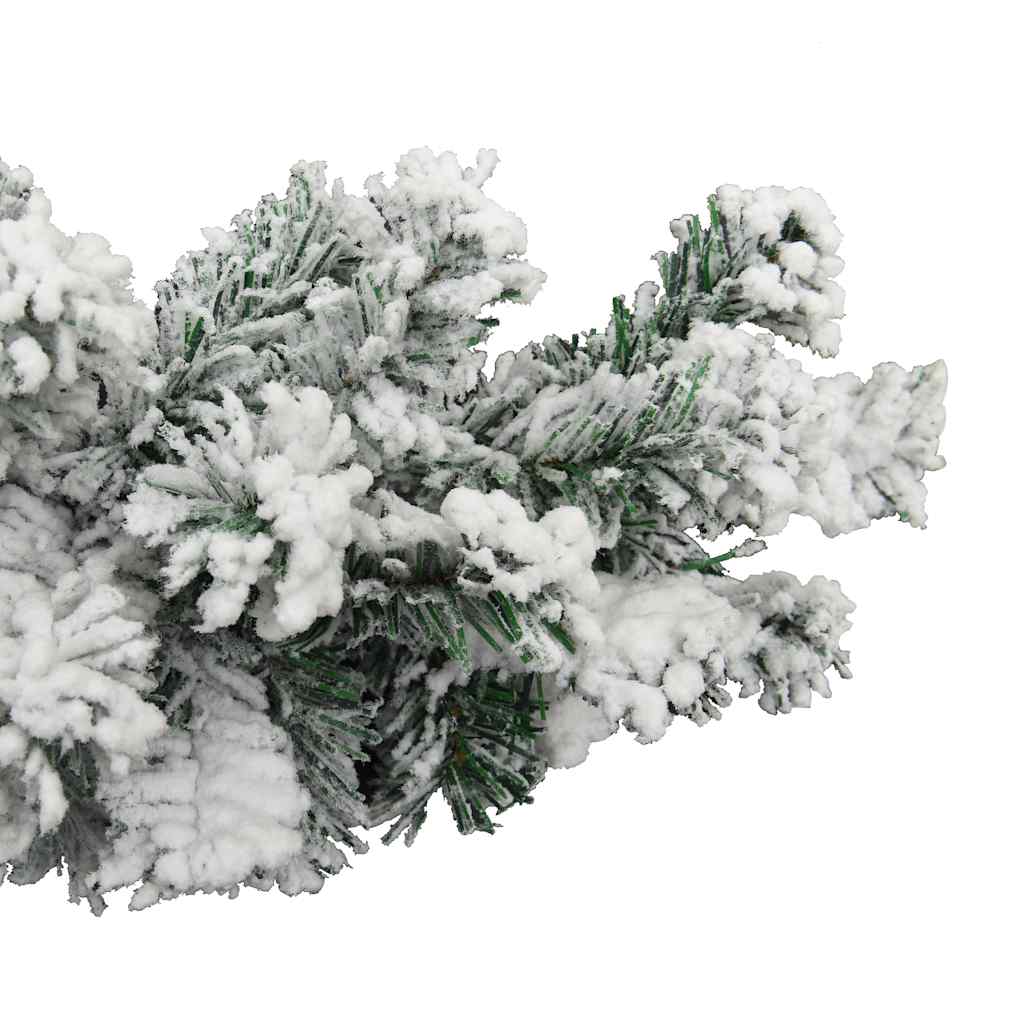 A close-up of a green Christmas garland heavily flocked with white artificial snow.