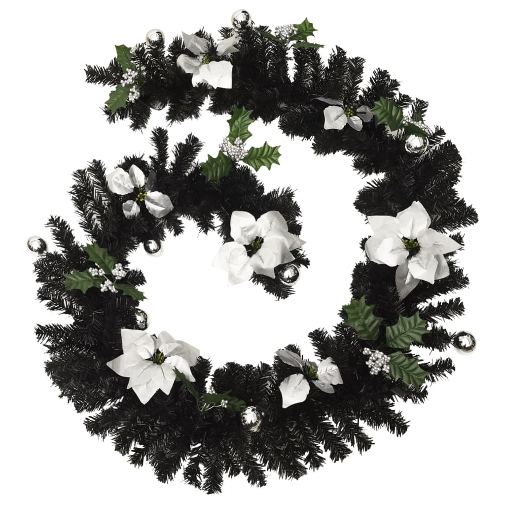 Black PVC Christmas garland with white poinsettias, bells, holly, and integrated LED lights, 8.9 feet long.