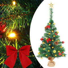 A 2ft pre-lit artificial Christmas tree in green with gold and red baubles, pine cones, bows, and a star topper.