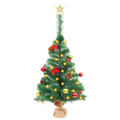 A 2ft pre-lit artificial Christmas tree in green with red and gold baubles, pine cones, bows, and a star topper on a burlap base.